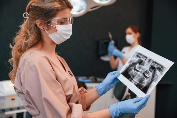 Periodontologas vertina dantų rentgeno nuotrauką ir planuoja gydymą | Slėnio klinika